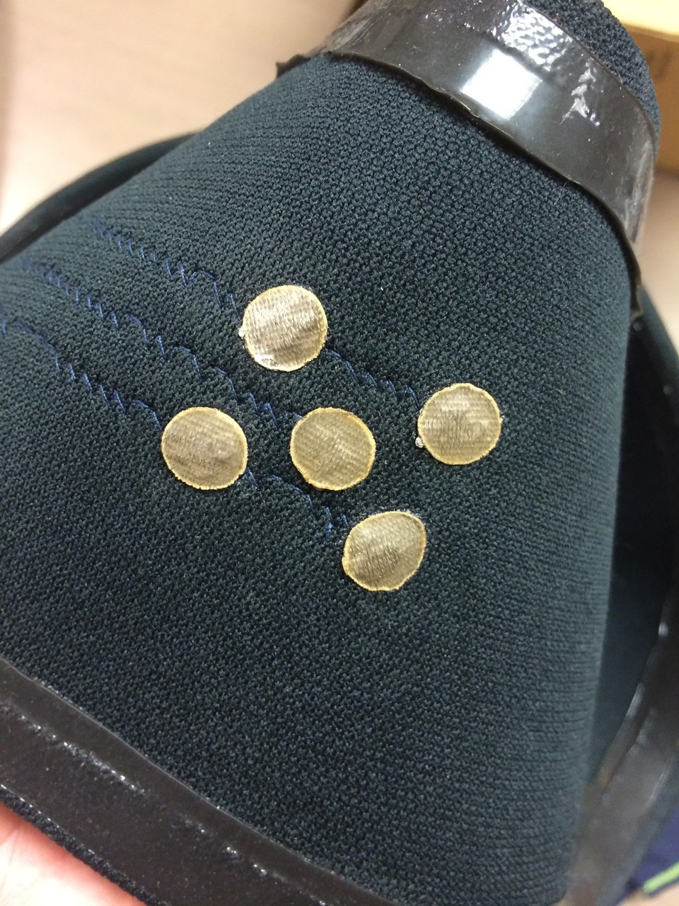 Five circular electrodes cut from conductive textile material for user comfort, arranged on the fabric band.